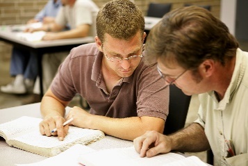 Two people looking at a document together. 