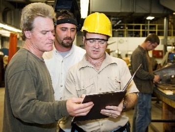 A group of workers all looking at a document together. 